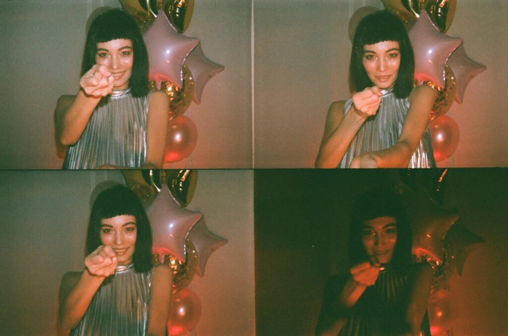 Elegant woman poses with shiny balloons in a playful, stylish setting.