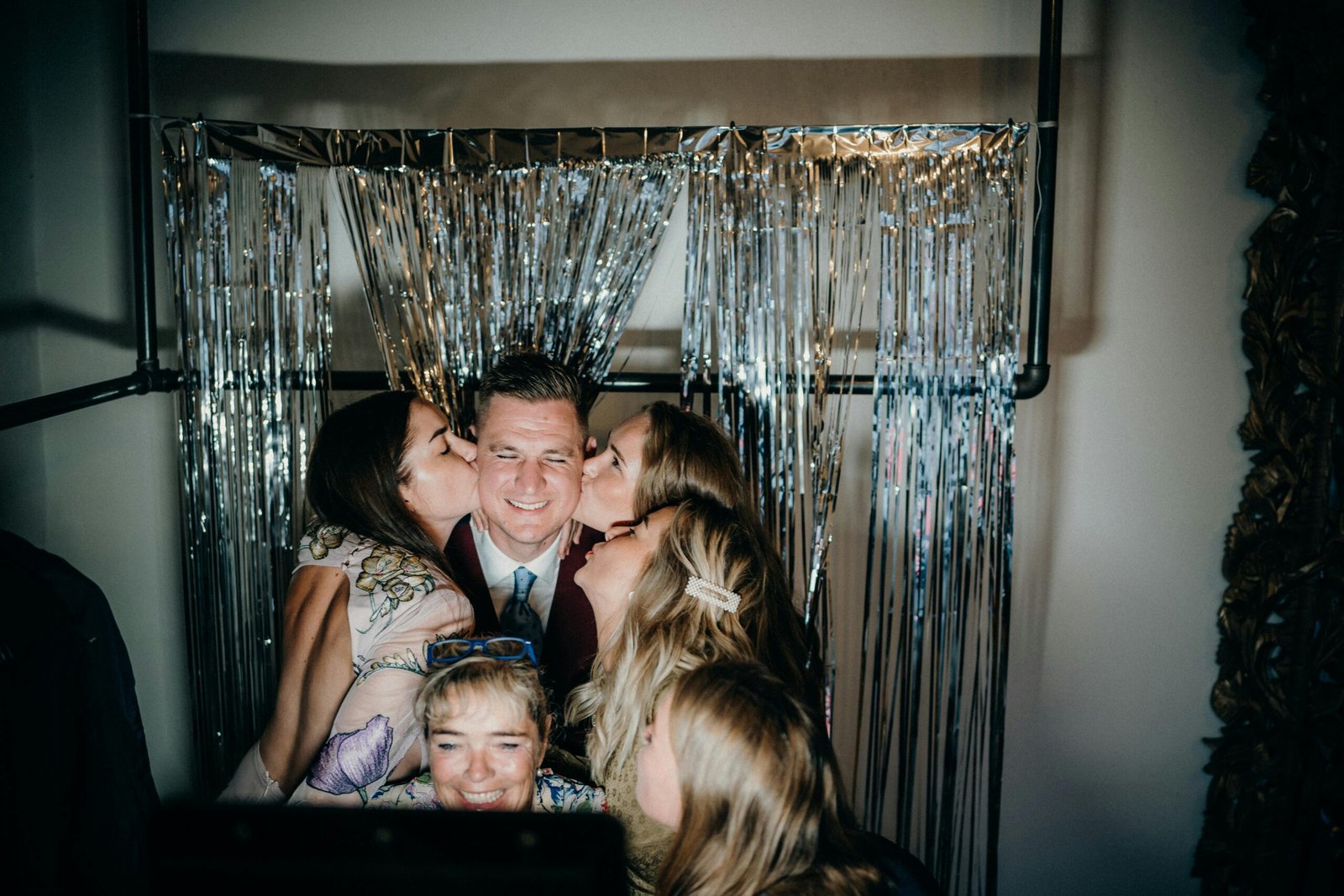 Group enjoying a fun photobooth moment at an indoor party with friends.